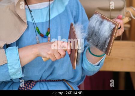 La technique traditionnelle de préparation de la laine consiste à brosser les fibres pour les rendre prêtes pour le filage en fil. Banque D'Images