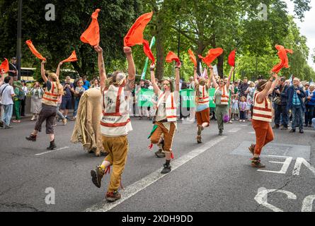 Londres / Royaume-Uni - 22 juin 2024 : les danseurs activistes morris mettent en scène un die-in à la marche Restore nature Now pour la protection de l'environnement. 350 groupes, dont la RSPB, WWF, National Trust, extinction Rebellion et d'autres, se sont unis pour la marche. Banque D'Images