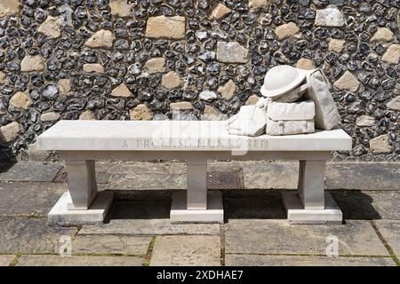 Banc en pierre commémoratif de la première Guerre mondiale avec un sac de kit de soldats, une bouteille d'eau, une baïonnette et un casque pour les soldats qui ont traversé Morn Hill. Winchester, Royaume-Uni Banque D'Images