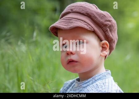 Portrait d'un beau et heureux petit garçon profitant d'une journée d'été ensoleillée dans un parc naturel. Le concept de loisirs actifs pour les enfants et la joie de Banque D'Images