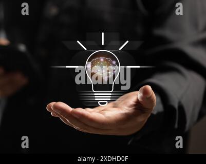 Homme d'affaires tient une ampoule avec un moteur d'intelligence artificielle sur sa main. technologie d'intelligence artificielle qui aidera à faire travailler via Banque D'Images