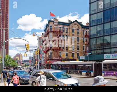 NYC Chinatown : 1 Division Street est des appartements au-dessus des magasins au coin de Catherine Street, avec des balcons en fer ; un drapeau chinois flotte du toit. Banque D'Images