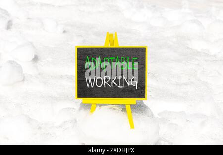 Symbole de travail adaptable. Mots conceptuels adaptables travaillant sur un beau tableau noir jaune. Beau fond de neige blanc. Travail adaptable aux entreprises Banque D'Images