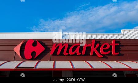 Enseigne et logo d'un supermarché Carrefour Market. Carrefour est une chaîne internationale française d'hypermarchés et un groupe de vente au détail présent dans le monde entier Banque D'Images