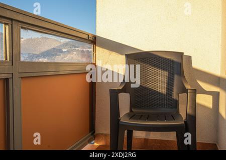 Chaise sur le balcon dans l'immeuble d'appartements tôt le matin Banque D'Images