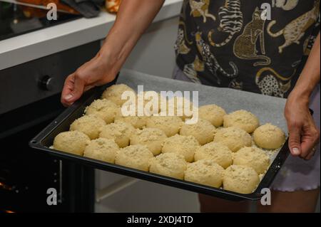 femme met les petits pains au four sur une plaque de cuisson 1 Banque D'Images