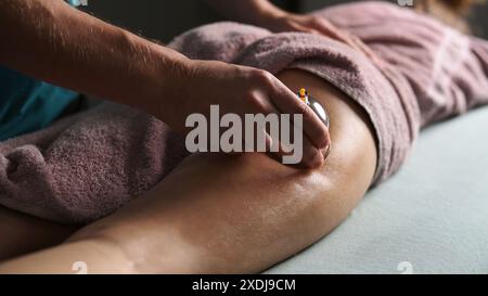 Procédures avec Une tasse à vide pour la ligne jeune femme sur Une table de massage pour se débarrasser de l'excès de graisse sur les fesses Banque D'Images