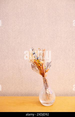 Bouquet de fleurs séchées dans un pot en verre sur une table en bois. espace de copie pour le texte ou la publicité Banque D'Images