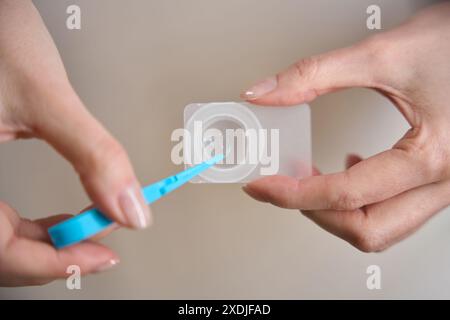 Femme met une lentille de contact dans un récipient Banque D'Images