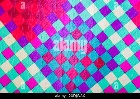 Motif géométrique coloré avec des formes de diamant dans des teintes vibrantes de rose, violet, bleu et vert. Banque D'Images
