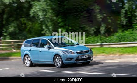 Milton Keynes, Royaume-Uni - 21 juin 2024 : 2009 Ford Focus bleu conduisant sur une route de campagne britannique Banque D'Images