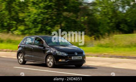 Milton Keynes, Royaume-Uni - 21 juin 2024 : 2017 Volkswagen Polo voiture conduisant sur une route de campagne britannique Banque D'Images