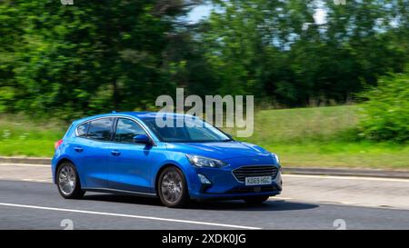 Milton Keynes, Royaume-Uni - 21 juin 2024 : 2020 Ford Focus bleu conduisant sur une route de campagne britannique Banque D'Images