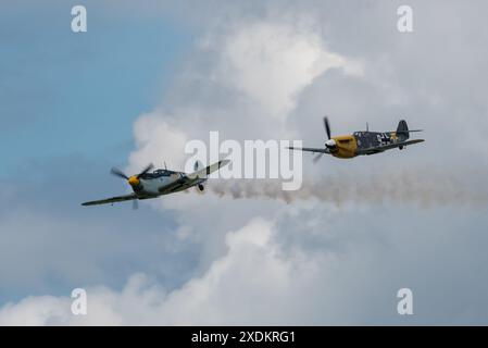 Aérodrome de Sywell, Northamptonshire, Royaume-Uni. 23 juin 2024. Le Sywell Airshow est un nouvel événement sur le calendrier du salon aéronautique avec un thème spécifique pour les avions de la seconde Guerre mondiale. L'avion hispano Buchon jouant le rôle des avions de chasse allemands Bf-109 de la Luftwaffe comme cible d'un « combat de chiens », avec une fumée traînante après avoir été « touché » Banque D'Images