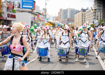 New York, États-Unis. 22 juin 2024. Les membres du groupe Fogo Azul NYC jouent lors de la 42e parade annuelle des sirènes à Coney Island à New York, le 22 juin 2024. Depuis 1983, des centaines de milliers de New-Yorkais et de visiteurs sont venus assister à ce défilé, inspiré des défilés du mardi gras de Coney Island du passé. Semblable aux années passées, cette année a présenté un large éventail de costumes festifs, maquillage, chars, bannières, musique, et bien plus encore. (Photo de Hailstorm Visuals/SIPA USA) crédit : SIPA USA/Alamy Live News Banque D'Images