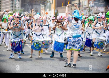 New York, États-Unis. 22 juin 2024. Les membres du groupe Fogo Azul NYC jouent lors de la 42e parade annuelle des sirènes à Coney Island à New York, le 22 juin 2024. Depuis 1983, des centaines de milliers de New-Yorkais et de visiteurs sont venus assister à ce défilé, inspiré des défilés du mardi gras de Coney Island du passé. Semblable aux années passées, cette année a présenté un large éventail de costumes festifs, maquillage, chars, bannières, musique, et bien plus encore. (Photo de Hailstorm Visuals/SIPA USA) crédit : SIPA USA/Alamy Live News Banque D'Images