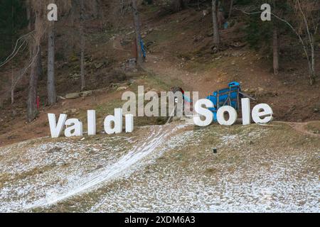 Italie, Trentin, Commezzadura - 21 décembre 2023 : Val di Sole est écrit en grandes lettres sur le parcours de course des VTT. Banque D'Images