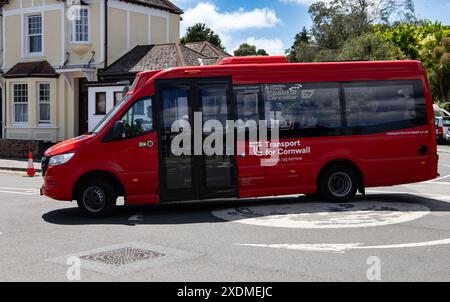 Minibus rouge de transport public à Cornwall étiqueté «transport for Cornwall» tournant un coin à Falmouth Cornwall. Banque D'Images