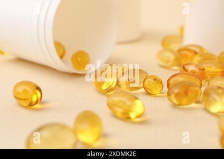 Bouteille avec capsules d'huile de poisson sur fond beige Banque D'Images