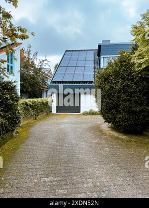 Francfort, Allemagne - 21 avril 2024 : Maison moderne avec plusieurs panneaux solaires sur le toit, conçue pour se protéger contre les problèmes d'électricité par harnais Banque D'Images