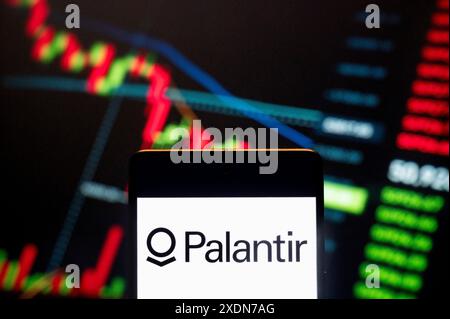 Dans cette illustration photo, la société américaine spécialisée dans les plates-formes logicielles pour l’analyse de big data, Palantir technologies (NYSE : PLTR), logo vu affiché sur un smartphone avec un graphique d’indice boursier économique en arrière-plan. Banque D'Images