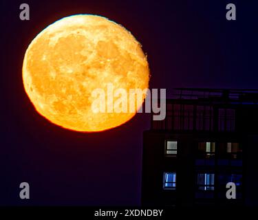 Glasgow, Écosse, Royaume-Uni. 24 juin 2024 : Météo britannique : lever de lune de fraise sur la tour du conseil dans l'ouest . S Credit : gerard ferry/Alamy Live News Banque D'Images