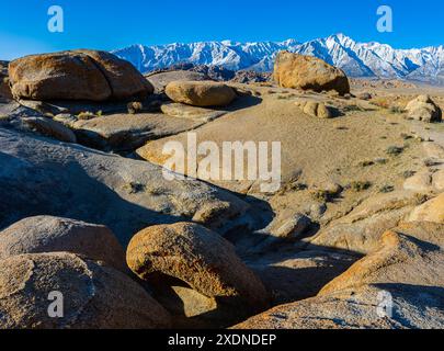 Formations rocheuses à travers le fond de la vallée avec Mt. Whitney et les montagnes de la Sierra Nevada enneigées, Alabama Hills National Scenic Area, Californie, Banque D'Images