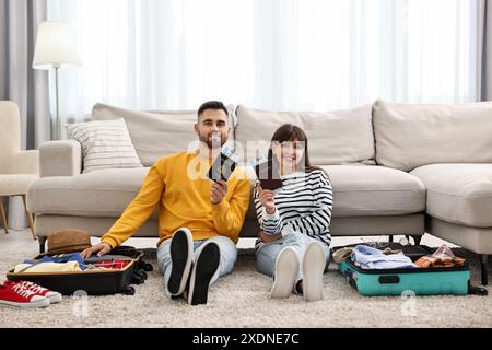 Couple avec passeports et billets près des valises à l'étage à l'intérieur Banque D'Images
