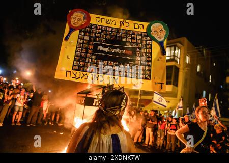 Un manifestant tient une pancarte avec des photos de l'otage israélien et des dessins animés de Netanyahou et Sinwar, sur laquelle on peut lire : « ils ne sont pas un jeu. Arrête ! Il n'y aura pas de gagnant ici' pendant la démonstration. Plus de 100 000 Israéliens ont manifesté à Kaplan avec les familles d'otages contre le premier ministre Benjamin Netanyahu, exigeant un accord immédiat sur les otages et un cessez-le-feu, suite au rassemblement, les manifestants avaient déclenché un feu de camp devant le « Metzudat Ze'ev » - le siège historique du Likoud, provoquant des affrontements avec la police israélienne. Banque D'Images