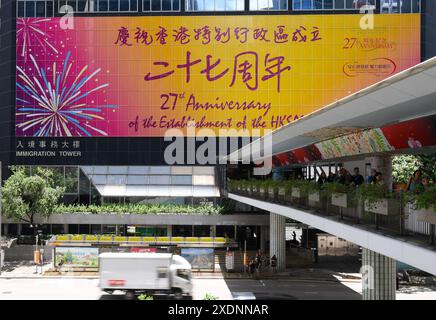 Pékin, Chine. 23 juin 2024. Une affiche sur le 27e anniversaire de la création de la région administrative spéciale de Hong Kong est vue sur la Tour de l'immigration à Hong Kong, dans le sud de la Chine, le 23 juin 2024. Cette année marque le 27e anniversaire du retour de Hong Kong à la patrie. Crédit : Chen Duo/Xinhua/Alamy Live News Banque D'Images