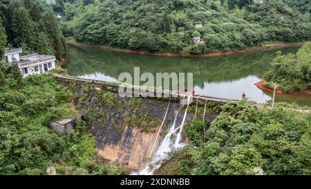 Pékin, Chine. 23 juin 2024. Une photo prise par un drone aérien le 23 juin 2024 montre des sauveteurs déchargeant de l'eau d'une zone de pontage dans le comté de Zhijin dans la ville de Bijie, dans la province du Guizhou au sud-ouest de la Chine. De fortes pluies récentes ont créé des zones de pontage dans le comté de Zhijin, dans la ville de Bijie, et les sauveteurs locaux ont effectué des missions pour décharger l'excès d'eau afin d'éliminer les risques potentiels. Crédit : Tao Liang/Xinhua/Alamy Live News Banque D'Images