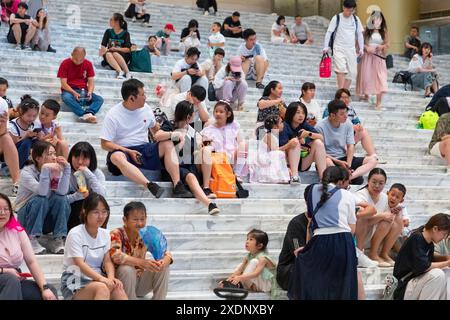 JINAN, CHINE - 23 JUIN 2024 - les gens sont assis sur les marches de la salle du musée du Shandong pour se rafraîchir dans la province du Shandong, province du Shandong en Chine orientale Banque D'Images