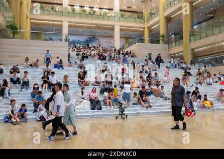 JINAN, CHINE - 23 JUIN 2024 - les gens sont assis sur les marches de la salle du musée du Shandong pour se rafraîchir dans la province du Shandong, province du Shandong en Chine orientale Banque D'Images