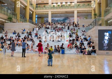 JINAN, CHINE - 23 JUIN 2024 - les gens sont assis sur les marches de la salle du musée du Shandong pour se rafraîchir dans la province du Shandong, province du Shandong en Chine orientale Banque D'Images