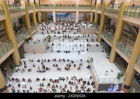 JINAN, CHINE - 23 JUIN 2024 - les gens sont assis sur les marches de la salle du musée du Shandong pour se rafraîchir dans la province du Shandong, province du Shandong en Chine orientale Banque D'Images