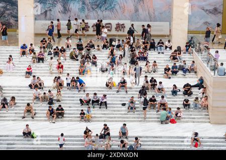 JINAN, CHINE - 23 JUIN 2024 - les gens sont assis sur les marches de la salle du musée du Shandong pour se rafraîchir dans la province du Shandong, province du Shandong en Chine orientale Banque D'Images