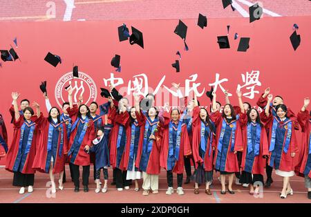 Pékin, Chine. 23 juin 2024. Les diplômés jettent leurs chapeaux en l'air à l'Université Renmin de Chine à Pékin, capitale de la Chine, le 23 juin 2024. L'université a tenu sa cérémonie d'ouverture ici dimanche. Crédit : Ren Chao/Xinhua/Alamy Live News Banque D'Images