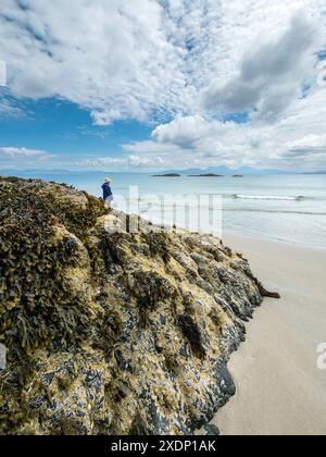 Les Paps de montagne du Jura sont visibles à l'horizon depuis la plage de Port a Chapuill sur l'île voisine de Colonsay dans les Hébrides intérieures, en Écosse, au Royaume-Uni Banque D'Images