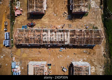 Vue aérienne du nouveau projet de construction de maisons dans la banlieue. Bâtiment résidentiel cadre de toit en bois avec ferme, poteau et poutres sur le chantier de construction. Fabrication de nouveau quartier dans la petite ville Banque D'Images