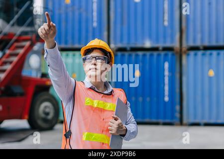 Succès ouvrier masculin debout point de main haut pour le travail de contrôle d'opération d'ordre dans l'industrie logistique d'expédition de cargaison. Banque D'Images