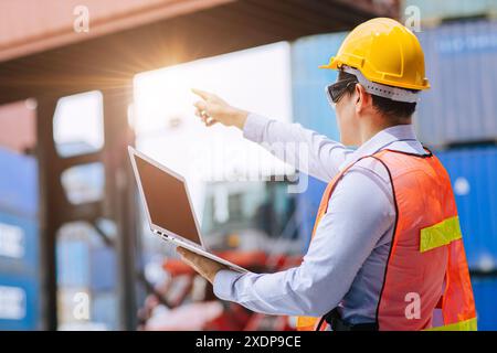 Succès ouvrier masculin debout point de main haut pour le travail de contrôle d'opération d'ordre dans l'industrie logistique d'expédition de cargaison. Banque D'Images