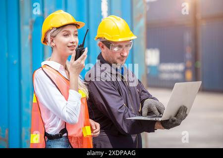 Équipe de travailleurs des douanes travaillant dans Port Cargo Shipping Container Yard ensemble, le contrôle de chargement radio fonctionne. Banque D'Images