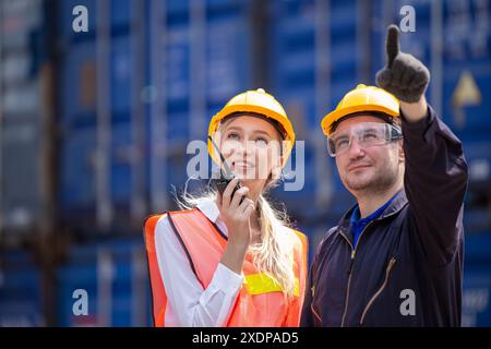 Équipe de travailleurs des douanes travaillant dans Port Cargo Shipping Container Yard ensemble, le contrôle de chargement radio fonctionne. Banque D'Images