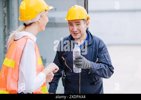 Happy Engineer Team Worker frein à eau potable soif détendre le travail sain en été chaud dans l'industrie maritime portuaire. Banque D'Images