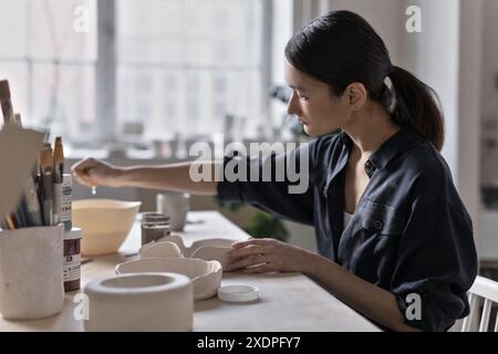 Artiste asiatique travaille à la table d'artisanat dans le studio de céramique Banque D'Images