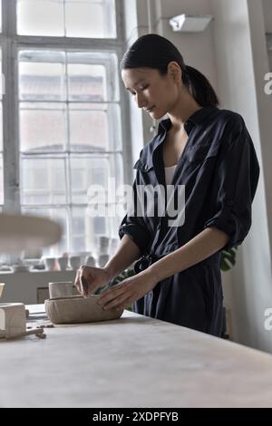 Artiste asiatique travaille à la table d'artisanat dans le studio de céramique. Banque D'Images