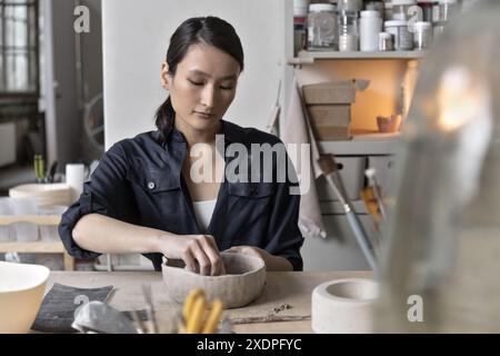 Artiste asiatique travaille à la table d'artisanat dans le studio de céramique Banque D'Images