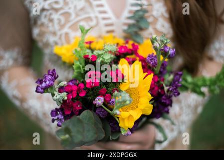 Modèle élégant présentant un bouquet vibrant dans le parc Banque D'Images