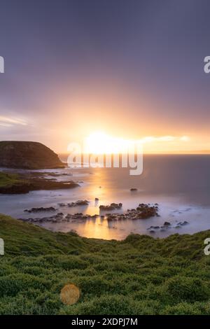 Lever du soleil sur la falaise côtière rocheuse avec l'océan lisse, Phillip Island Banque D'Images