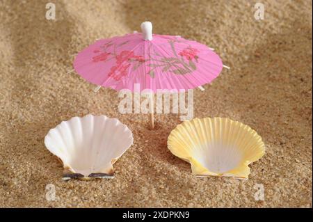 Ferien und Urlaub am Strand Ein Modell-Sonnenschirm mit zwei Muschelschalen symbolisieren Urlaub am Strand *** vacances sur la plage A Banque D'Images